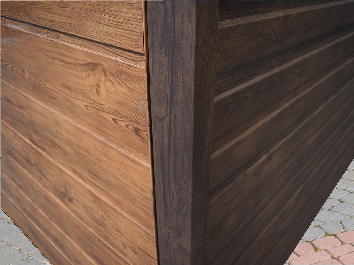 Plechová garáž v drevodekore – detail rohovej lišty a oplechovania rohu.