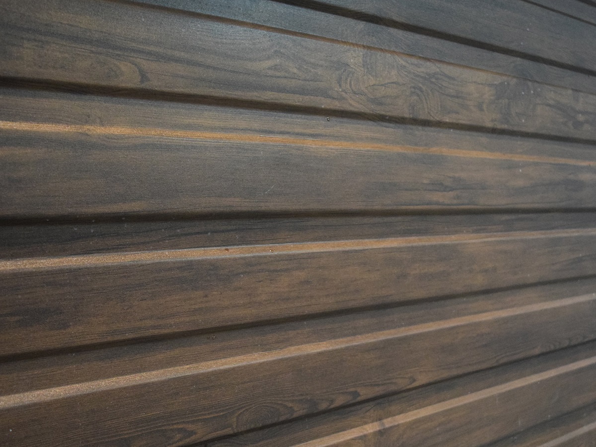 Detail opláštenia plechovej garáže – vodorovný trapézový plech v drevodekore.