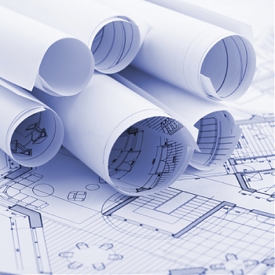 Rolované technické výkresy a projektová dokumentácia na stole